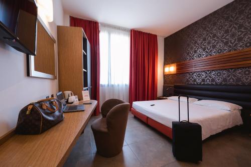 a hotel room with a bed and a chair at Hotel Cosmopolitan Bologna in Bologna