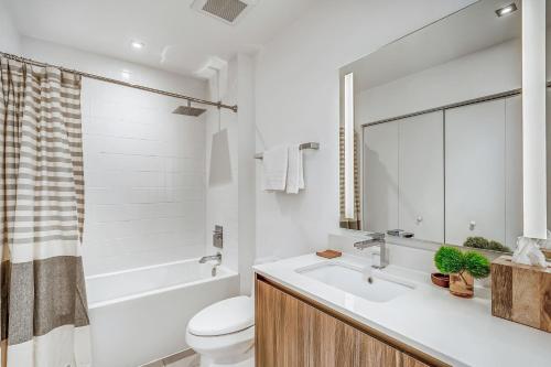 a bathroom with a sink and a toilet and a tub at Sentral Wynwood in Miami