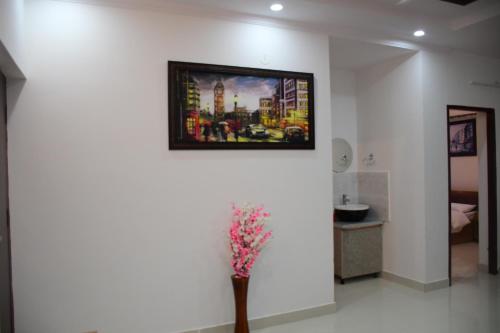 a room with a painting on the wall and a vase with flowers at River Stay - Homestay by Wanderlust Rural Tourism in Dehradun