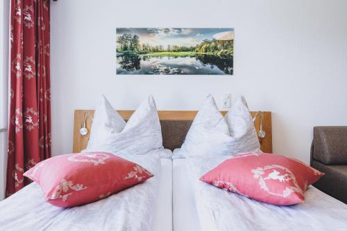 een slaapkamer met twee bedden met rode en witte kussens bij Appartement Farina in Kaprun