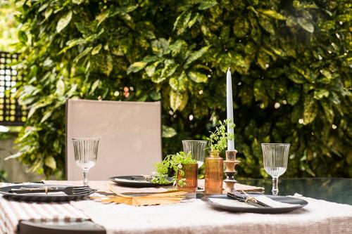 una mesa con un mantel blanco con platos y copas de vino en NEW Apartment & Terrace. Steps to Ondarreta Beach en Añorga-Lugariz