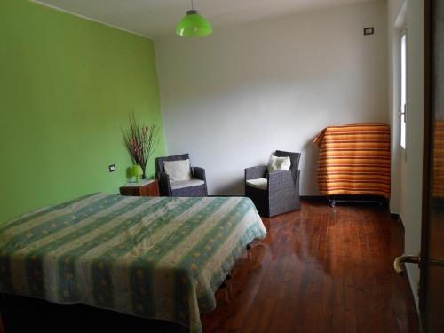 ein Schlafzimmer mit einem Bett und zwei Stühlen darin in der Unterkunft La Lantana in San Vito