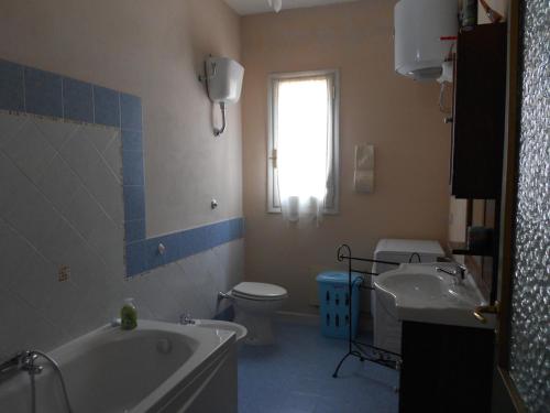 ein Badezimmer mit einer Badewanne, einem WC und einem Waschbecken in der Unterkunft La Lantana in San Vito