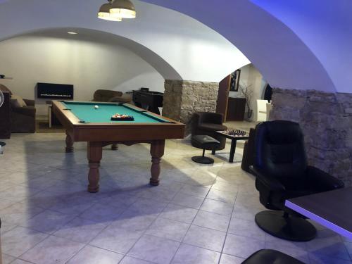 um quarto com uma mesa de bilhar e algumas cadeiras em Penzion B5 em Kežmarok