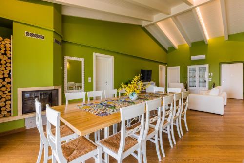 a dining room with green walls and a table and chairs at Villa Lerant in Acquaviva Picena