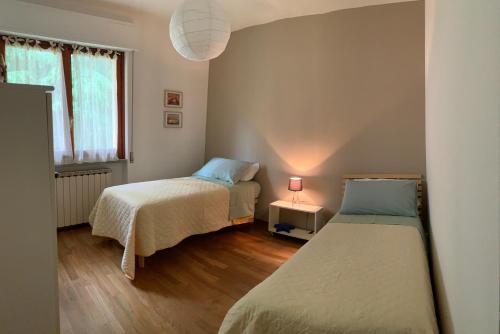 a room with two beds and a window and a lamp at Home53 in Arezzo