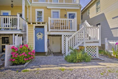 a yellow house with a blue door and some flowers at Charming Ocean City Townhome Walk to Beach! in Ocean City