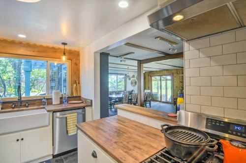 a kitchen with a stove top oven next to a counter at Scenic Lake Almanor Home with Mountain Views! in Lake Almanor
