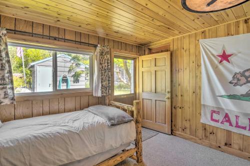 1 dormitorio con 1 cama en una cabaña de madera en Scenic Lake Almanor Home with Mountain Views!, en Lake Almanor