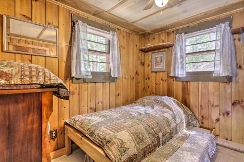 1 dormitorio con 1 cama en una habitación de madera en Lake Hermit Cabin with Kayaks and Paddleboards! en Sanbornton