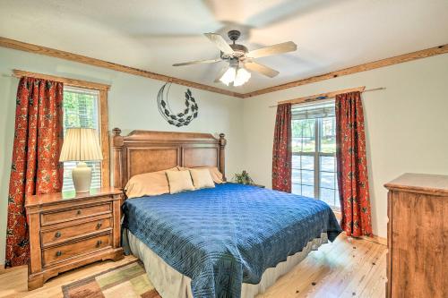 Un dormitorio con una cama y un ventilador de techo. en Cabin in Resort - half Mi to Guntersville Lake!, en Guntersville