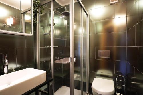 a bathroom with a shower and a toilet and a sink at Lauchernalp Resort Residences in Wiler