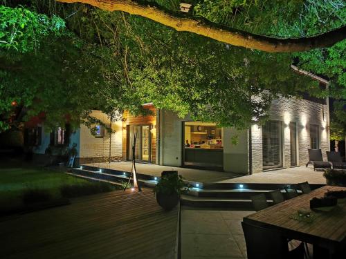 a backyard at night with a house at Bed & Bokes aan de Maaskant in Lanaken