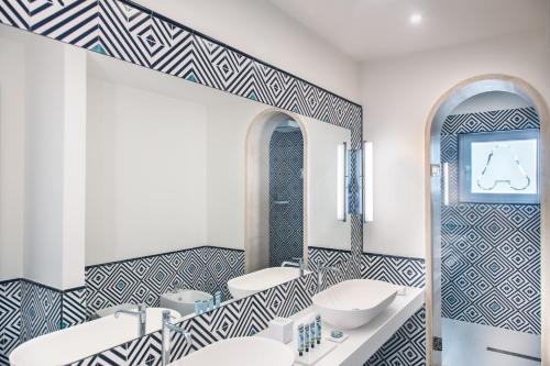 a bathroom with two sinks and a mirror at Pazziella Garden & Suites in Capri