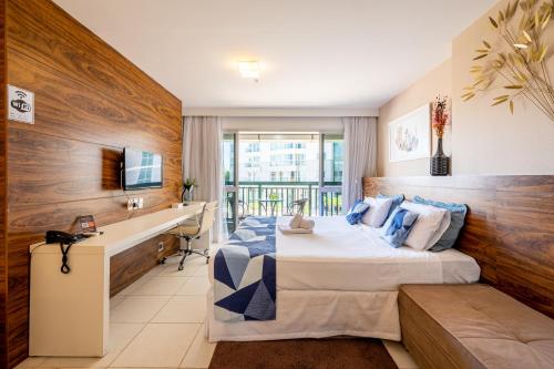 una camera d'albergo con letto, scrivania e TV di BSB STAY EXECUTIVE FLATS PARTICULARES -SHN a Brasilia