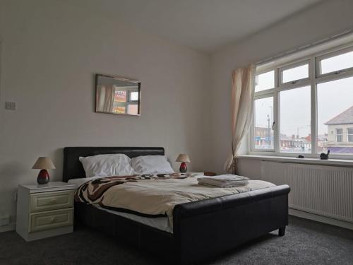 a bedroom with a large bed and a window at Victoria's Apartment - 3 Large Bedroom in Blackpool