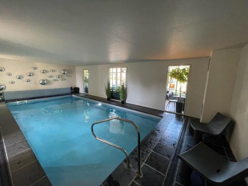 a large swimming pool in a house at Hôtel - Spa Les Corderies in Saint-Valery-sur-Somme