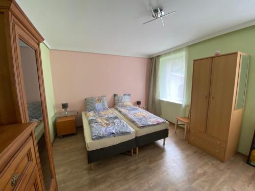a small bedroom with a bed and a cabinet at Ratuszowa Noclegi in Szczawno-Zdrój