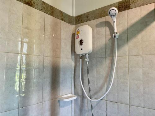 een douche in de badkamer met aitizer aan de muur bij Kunna House in Ko Yao Noi