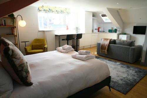 um quarto com uma cama grande e toalhas em The Old Bakery em Sherborne