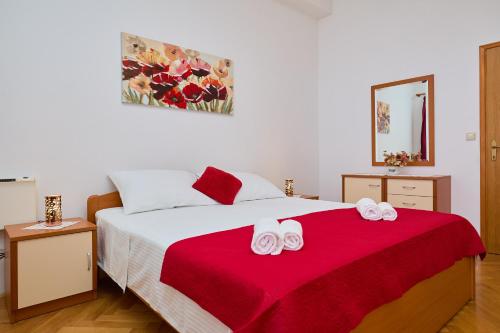 米利尼的住宿－Apartman Ani，一间卧室配有一张带红色毯子的大床