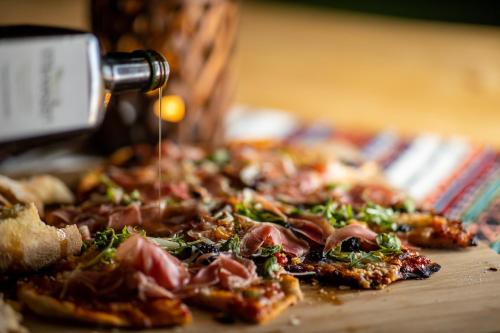 a pizza being drizzled with sauce on a table at Villa Trésor Voronet in Gura Humorului