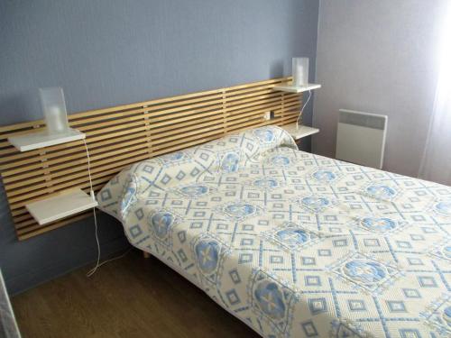 1 dormitorio con 1 cama con cabecero de madera en Gîtes Merour - Telgruc, en Telgruc-sur-Mer