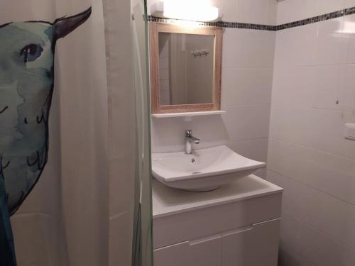 a white bathroom with a sink and a mirror at Gîtes Merour - Telgruc in Telgruc-sur-Mer