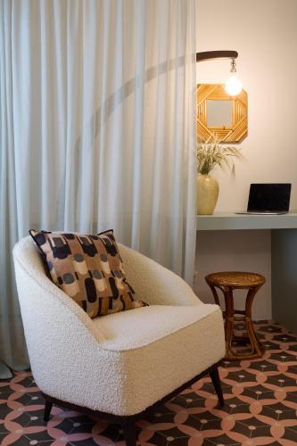 a living room with a chair and a table at Villa Marengo Guest House in Spinetta Marengo