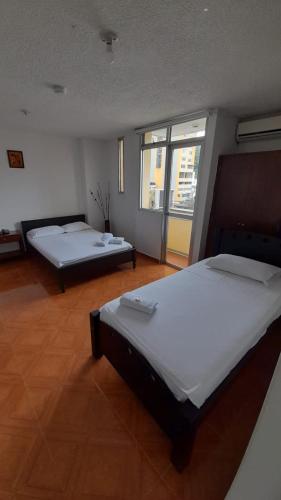 two beds in a large room with at Hotel Centauros del Llano in Villavicencio