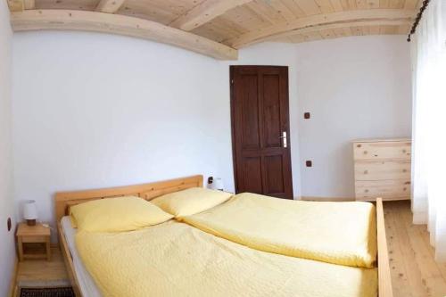 een slaapkamer met een groot bed met gele lakens bij Apartma Mlekuž in Bovec