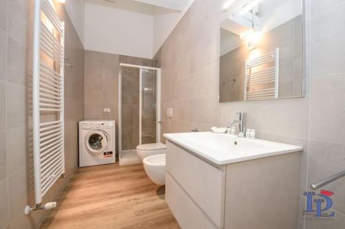 uma casa de banho com um lavatório e uma máquina de lavar roupa em Desenzanoloft Peler em Desenzano del Garda
