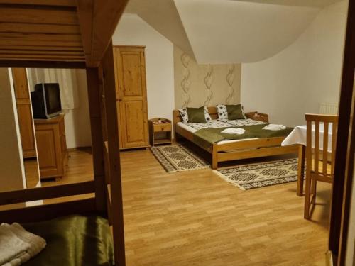 a bedroom with two beds and a tv in a room at Kincses Panzió in Praid