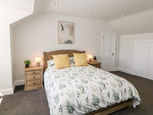 a bedroom with a large bed and two night stands at Sunshine Apartment in Belper