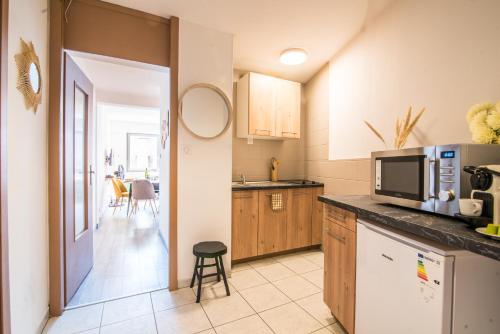 une cuisine avec un micro-ondes et un plan de travail dans l'établissement Hyper-centre - Le Saint-Pierre - Cathédrale, à Strasbourg