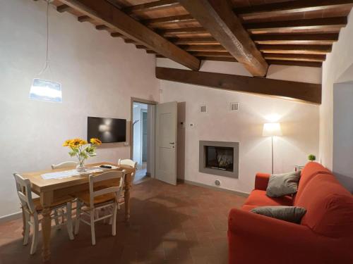 a living room with a table and a red couch at Appartamento Podere la Chiusa in Sesto Fiorentino