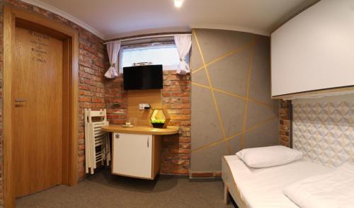 Habitación pequeña con cama y escritorio. en Pokoje Wieliczka, en Wieliczka