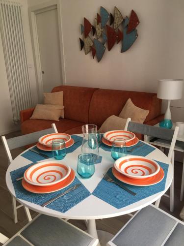 une table avec des assiettes et des verres au-dessus dans l'établissement La Terrazza sul mare - Dimora di Charme, à Giovinazzo