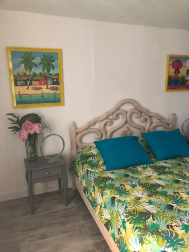 a bedroom with a bed with blue pillows and a table at La Nectarine in Nice