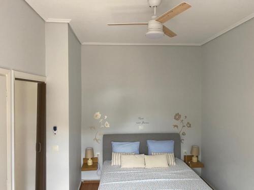 sypialnia z łóżkiem i wentylatorem sufitowym w obiekcie Cozy seaside studio in Lemos Vouliagmenis w Atenach