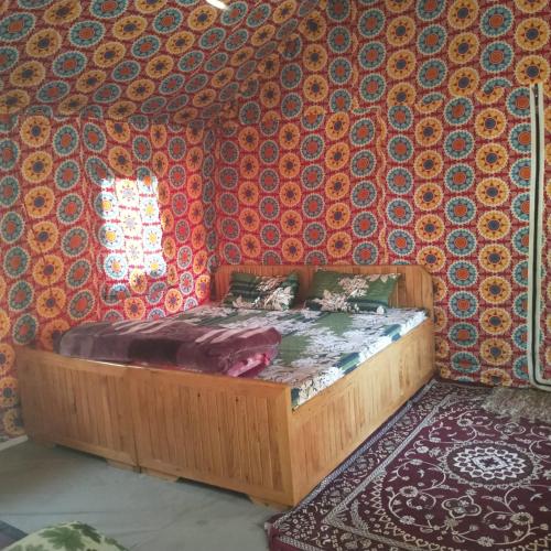 1 dormitorio con cama de madera en una habitación en Snow View Himalayan Adventure, en Kasol