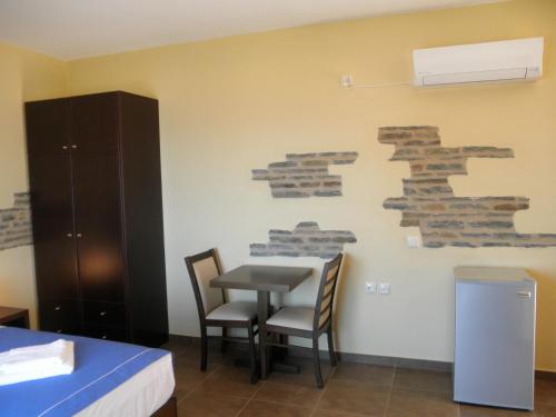 モネンバシアにあるVilla Cazalaのテーブルと椅子が備わる壁の客室です。