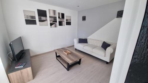 a living room with a couch and a coffee table at LE ROCAGERMANOIS - Jolie maison de village in Saint-Germain-le-Rocheux