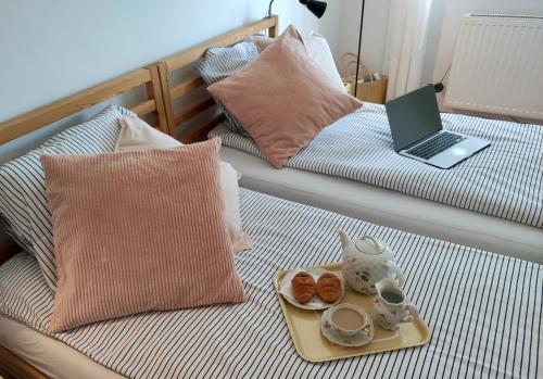 a bed with a laptop and a tray with donuts on it at Apartament MAZI w centrum PRIMORE in Gdańsk