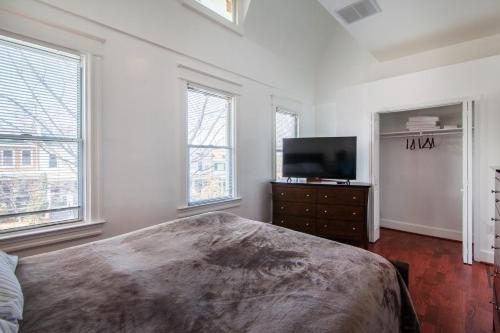 1 dormitorio con 1 cama y TV de pantalla plana en Spacious, Relaxing, 4 Bd 3.5 Ba Home In Petworth! en Washington