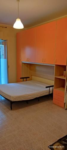 a large bed in a room with orange cabinets at Monolocale Banco Monteforte in Calatabiano