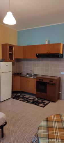 a kitchen with a white refrigerator and a stove at Monolocale Banco Monteforte in Calatabiano