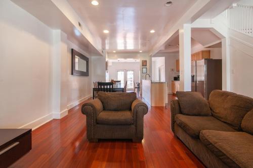 a living room with a couch and chairs and a kitchen at Spacious, Relaxing, 4 Bd 3.5 Ba Home In Petworth! in Washington, D.C.