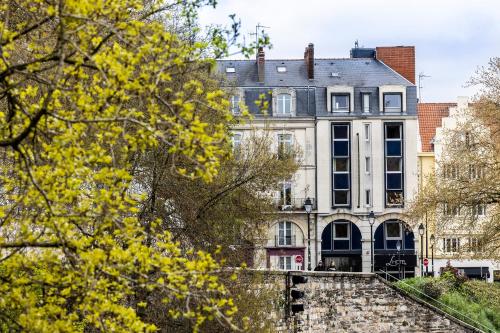 um edifício na cidade com árvores amarelas em L'Hôtel em Nantes