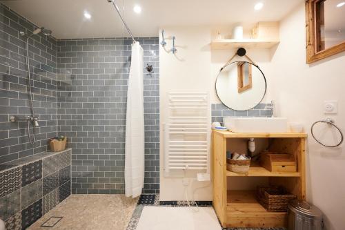 ein Bad mit blauen Fliesen, einem Waschbecken und einer Dusche in der Unterkunft Casa MaMa&ly in Bellentre
